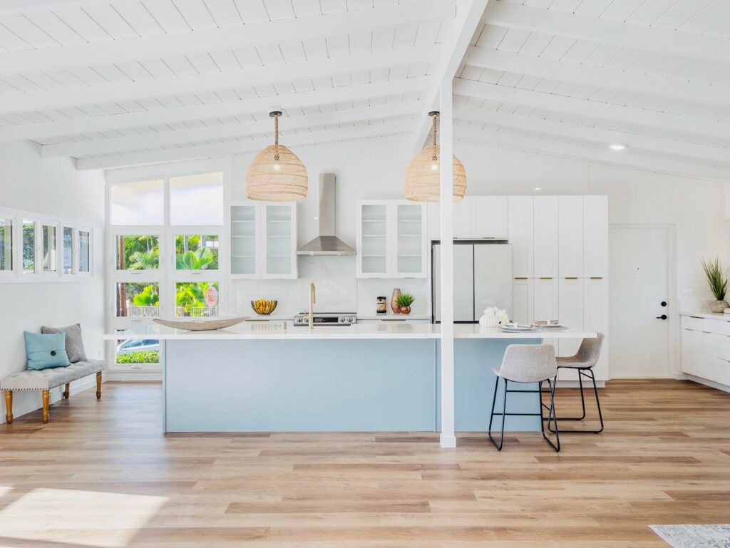 Spacious open-concept kitchen and living room featuring light wood-look Vinyl flooring, a large island by Degraaf Interiors in Grand Rapids, MI.