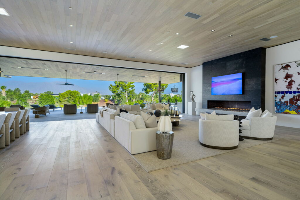 Expansive modern living room with light vinyl plank flooring, indoor-outdoor flow, and a sleek fireplace by Degraaf in Grand Rapids and Hudsonville MI.