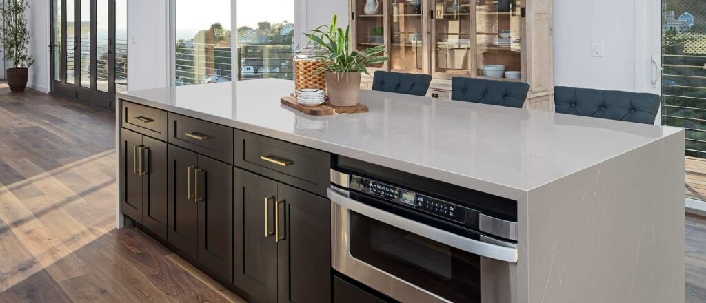 White quartz kitchen countertop with dark cabinets and stainless steel appliances
