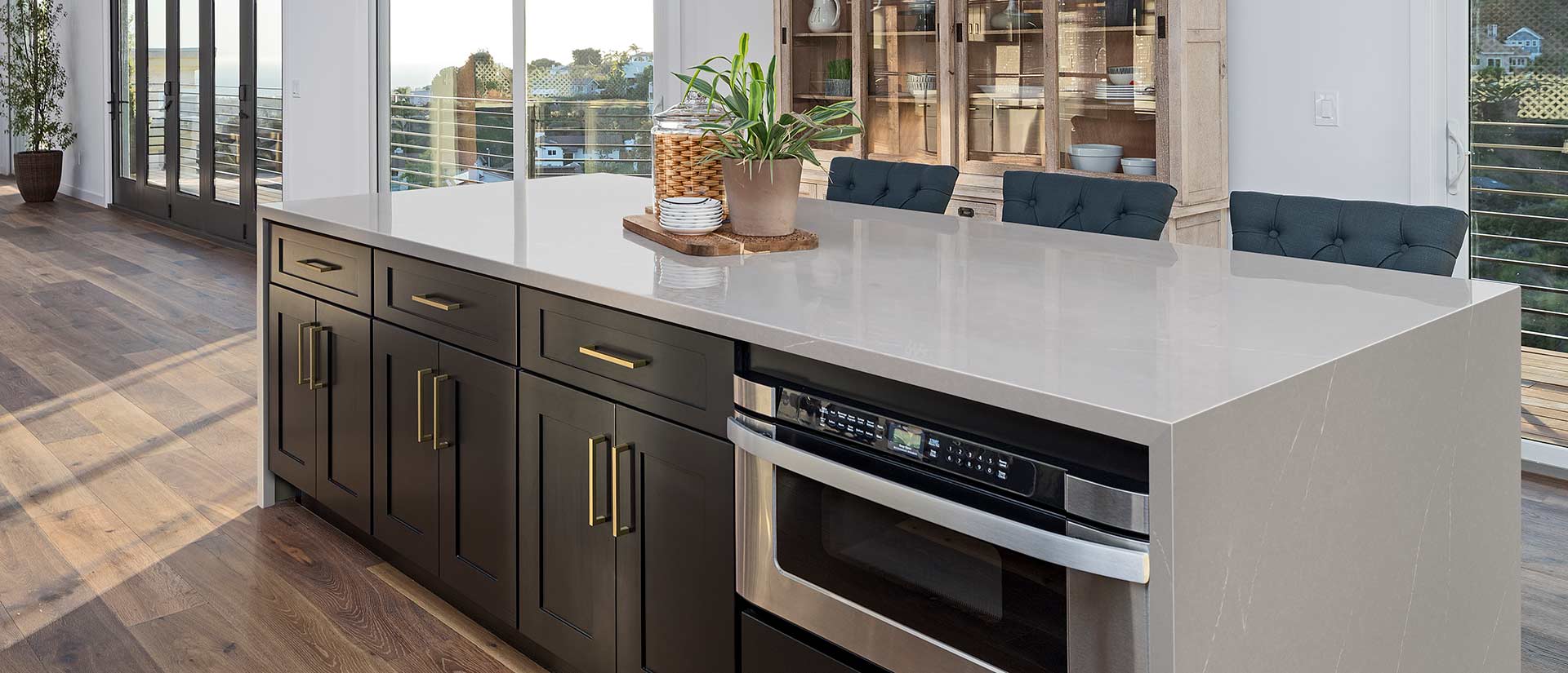 White quartz kitchen countertop with dark cabinets and stainless steel appliances